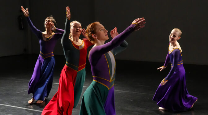 Four dancers in long dresses, running.